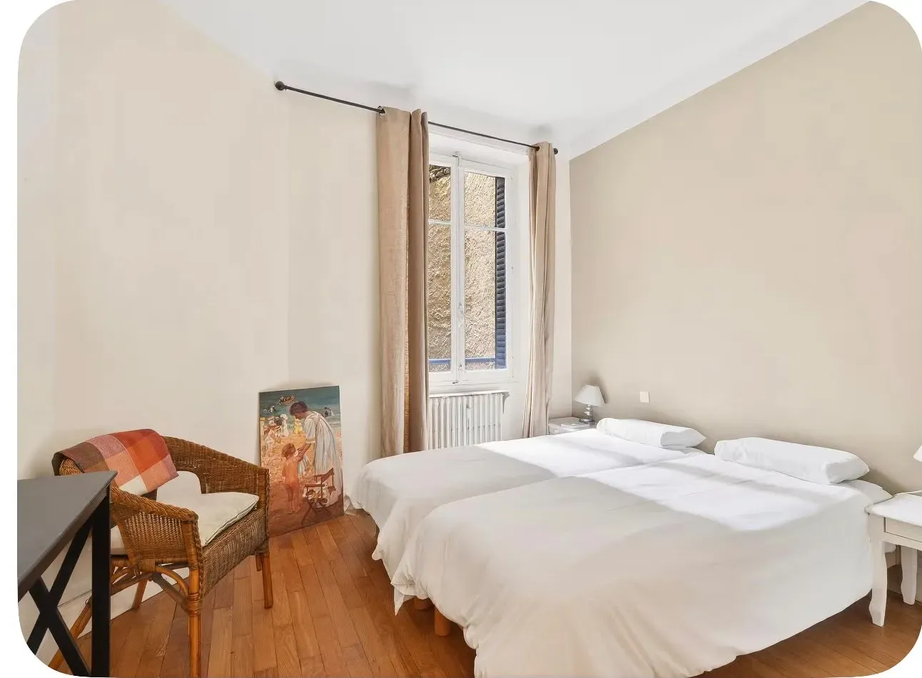 Chambre deux lits en linge blanc dans un appartement ancien à parquet